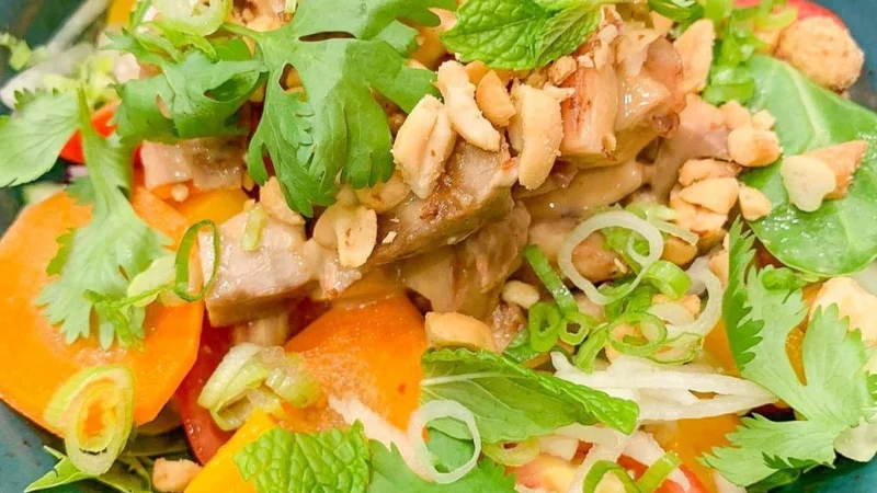 Ensalada tailandesa con pollo, mango, cacahuetes y hierbas frescas