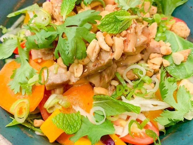 Ensalada tailandesa con pollo, mango, cacahuetes y hierbas frescas
