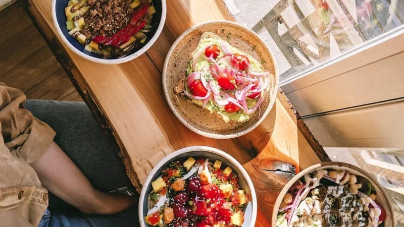 bowls de açaí, tostadas de aguacate y un batido en el mostrador de un café soleado
