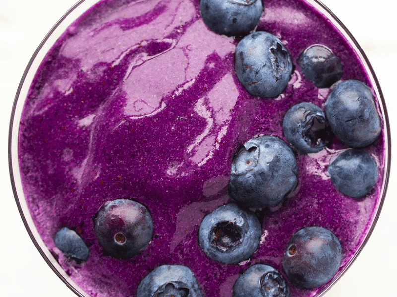 Tazón de smoothie morado cubierto con arándanos