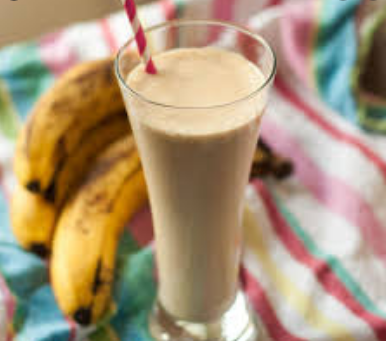 smoothie de plátano y mantequilla de maní en un vaso con plátanos